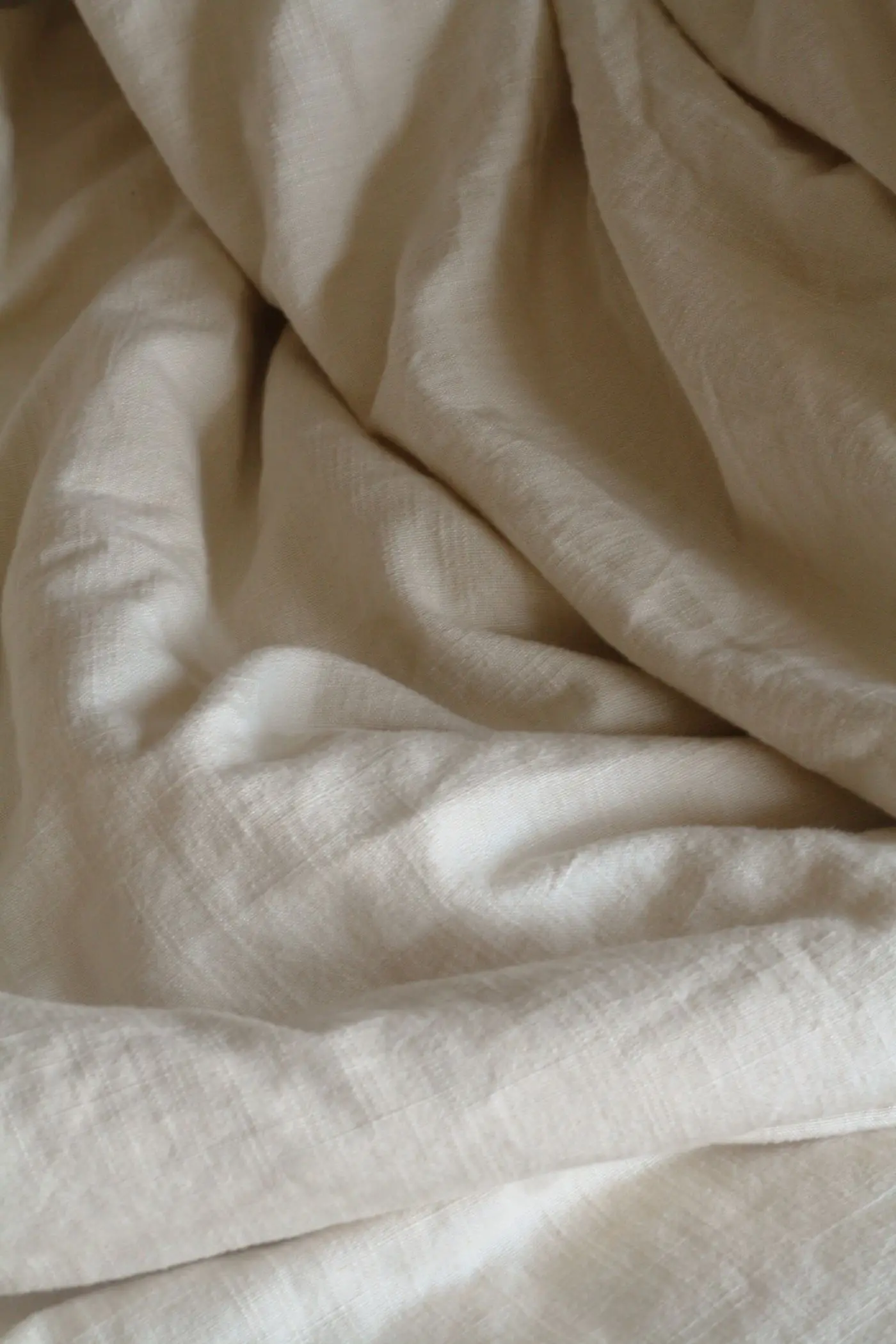Soft ivory cotton fabric gathered into gentle folds