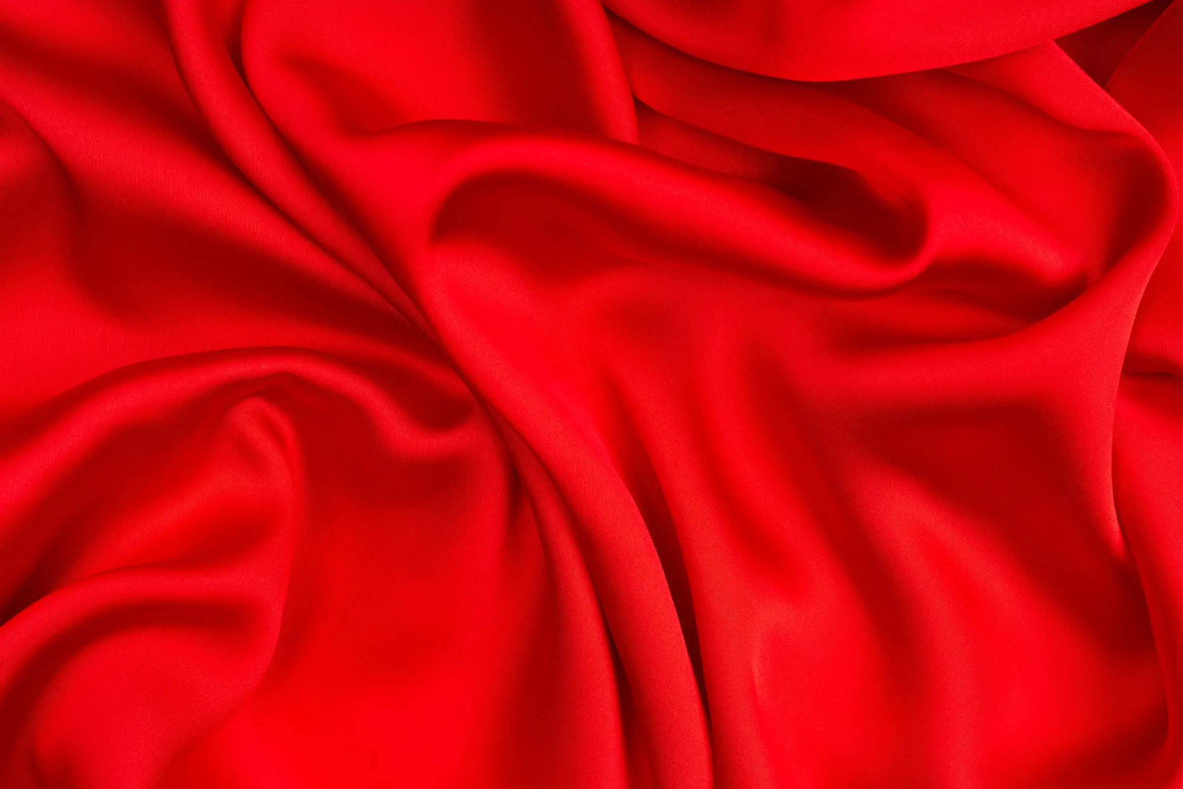 Deep red fabric arranged in soft, sweeping folds
