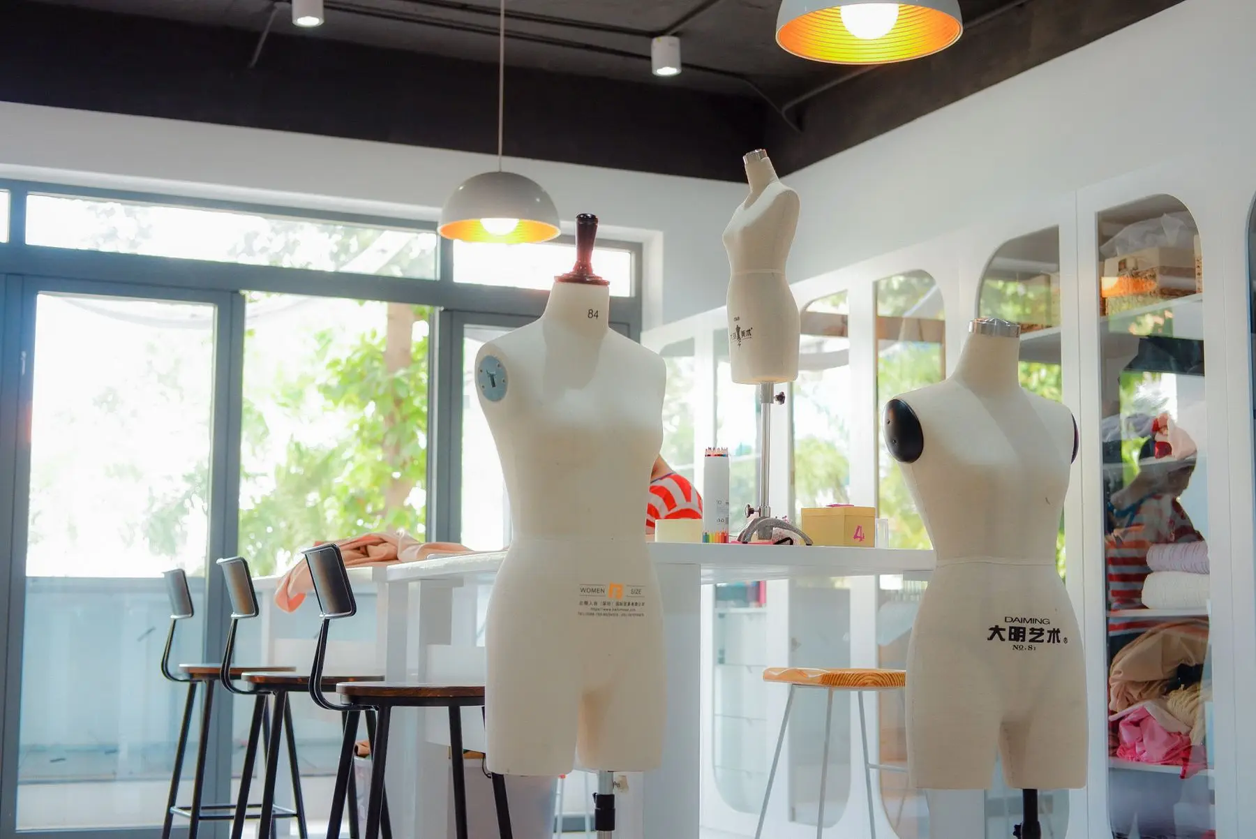 A dress form and sewing machine in a bright home sewing studio